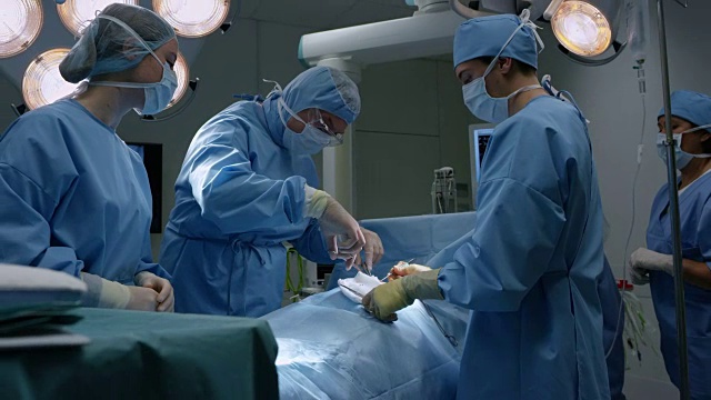 女性外科技师将器械交给男性外科医生视频素材