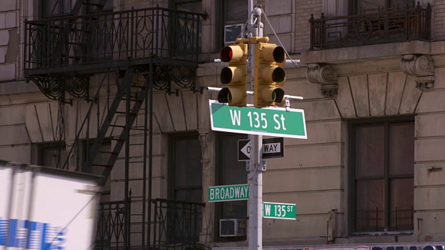 哈林区百老汇大街135号的路标。汽车进进出出，模糊了路牌。视频下载