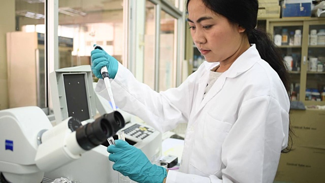 年轻的亚洲女科学家在实验室里用吸管工作视频素材
