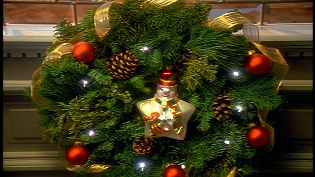 从近景的花环倾斜到反射的圣诞树+壁炉和长袜在客厅视频下载