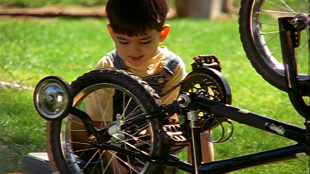 西班牙男子+小男孩在户外修理自行车视频素材