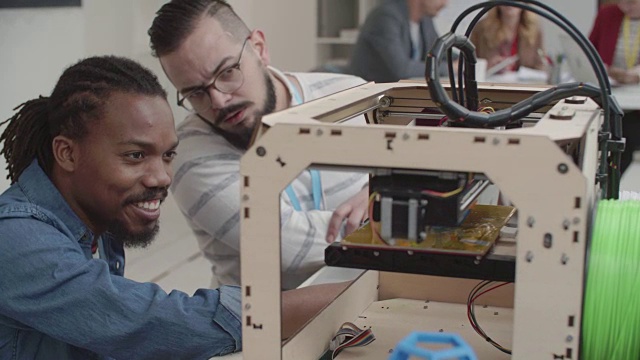 4K:在初创公司3D打印办公室工作的创意人士。视频素材