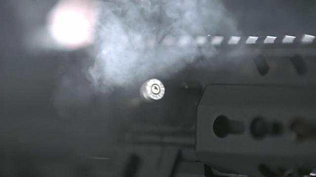 近距离观察用过的炮弹，子弹，子弹和烟雾从一个半自动武器被发射到一个目标范围(超慢动作从Phantom Flex)。视频下载