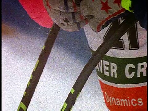慢动作近景倾斜下倾斜上俄罗斯滑雪者在色彩鲜艳的衣服倚靠在滑雪杆+等待/科罗拉多视频下载