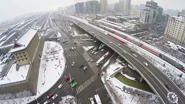 下雪后西安古城墙附近的公路和铁路交通航拍。视频下载