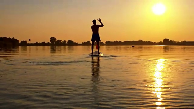 日落时，一个SUP在湖上的剪影视频素材