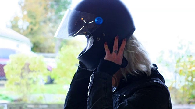 准备骑摩托车时戴上摩托车头盔的女人视频下载