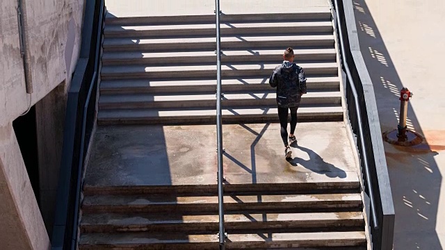 年轻的男运动员在体育场的楼梯上奔跑视频素材
