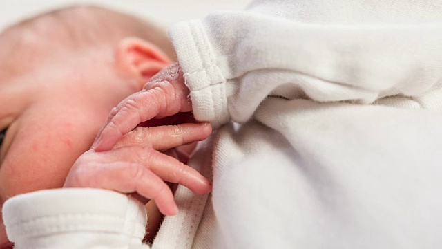 刚出生的女婴环顾四周，动着手指视频素材