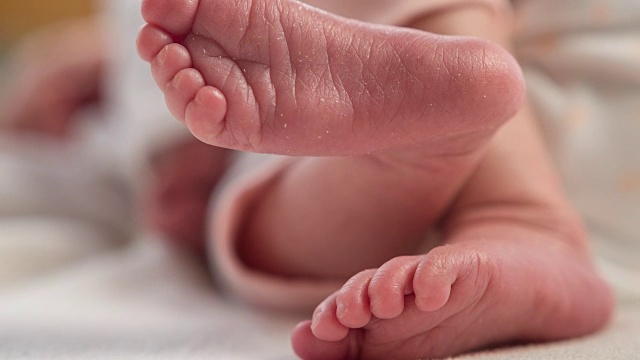 刚出生的女婴躺着，用脚踢来踢去视频素材