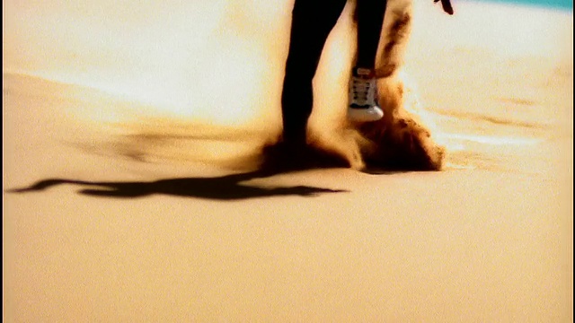 过度曝光的慢动作黑人男性运动员的腿跑下沙丘的一边向相机视频素材