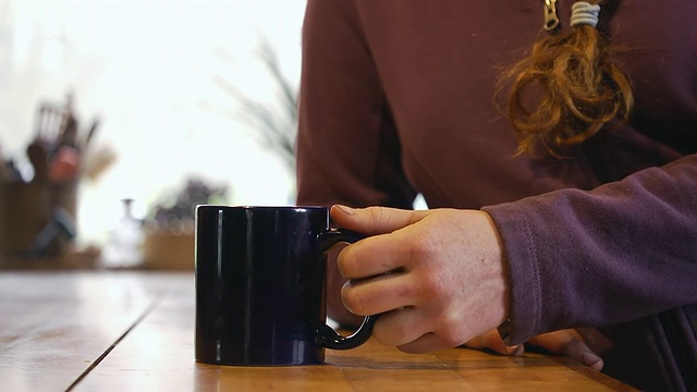 美国密歇根州查塔姆市，勤劳的妇女拾起咖啡杯视频素材