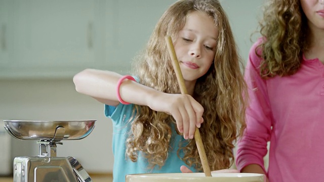 英国汉普斯特德伦敦，女孩们将食材倒入搅拌碗中视频下载