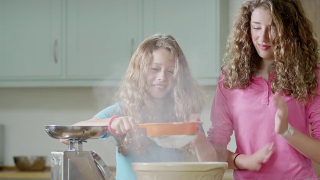 英国汉普斯特德伦敦，女孩们将面粉倒入搅拌盆中视频下载