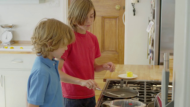 英国汉普斯特德伦敦，男孩们在厨房里一起做煎饼视频下载