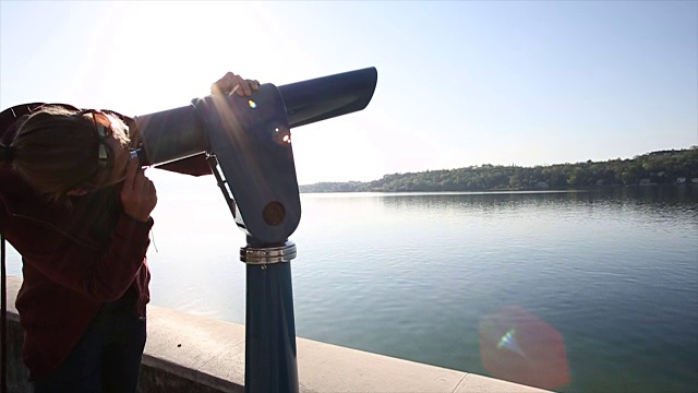 年轻人用测距仪，望过平静的湖面视频下载