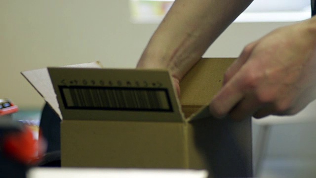 一个男人正在打包一个小盒子视频素材