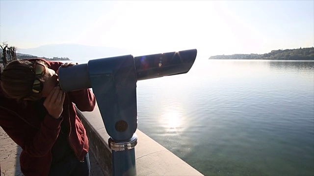 年轻人用测距仪，望过平静的湖面视频下载