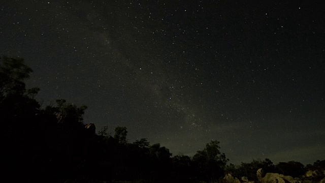 星空在夜晚在山脊后面旋转视频下载