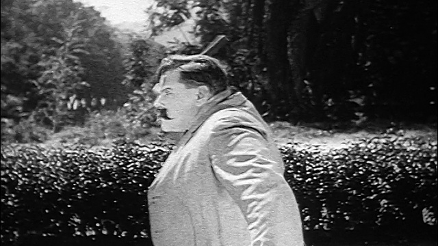 B/W 1926档案人(弗农登特)站在外面举起锤子/头飞离锤子视频素材