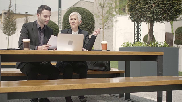 商务人士在科技园户外坐着使用笔记本电脑。视频素材