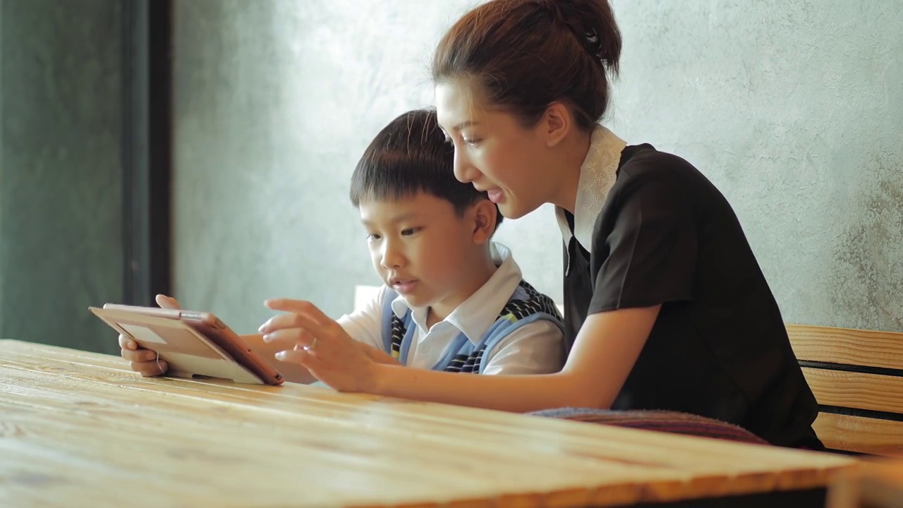 亚洲母亲和儿子使用平板电脑视频素材