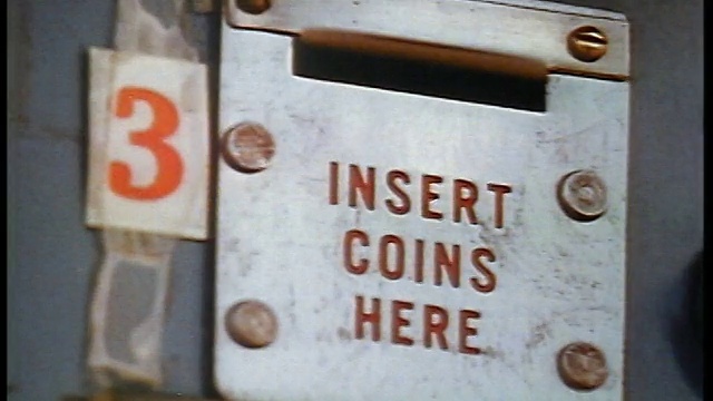 1957年，镜头非常近，一名男子将硬币插入自动售货机的投币口视频下载