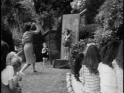 1955年后景:一名妇女向屋外的小女孩投掷刀子，前景是孩子们视频下载