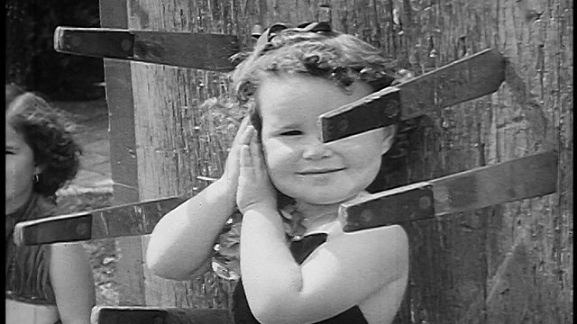 1955年B/W特写小女孩站在板上，刀扔在她周围/手势对着相机视频下载