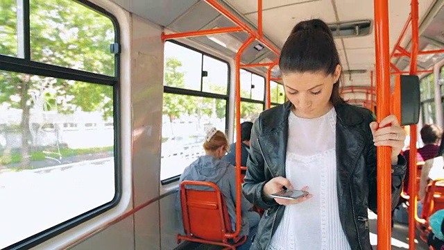 漂亮的年轻女子在电车/火车上使用手机。视频下载