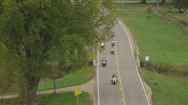 美国威斯康辛州索克县的乡村道路上，摩托车骑手在弯道上行驶视频下载