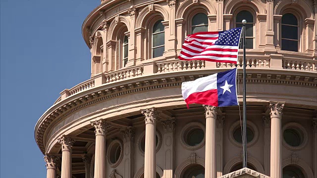 美国国旗和德州国旗在奥斯丁的德州国会大厦飘扬视频素材