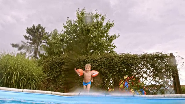 水下拍摄的一个男孩和游泳者跳进游泳池视频下载