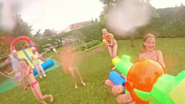 爸爸在儿童派对上和孩子们打水枪视频素材