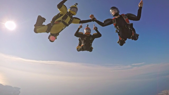 三名跳伞运动员在空中手拉手视频下载