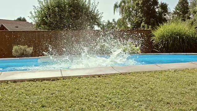 一个女孩和她的弟弟跳进游泳池视频素材