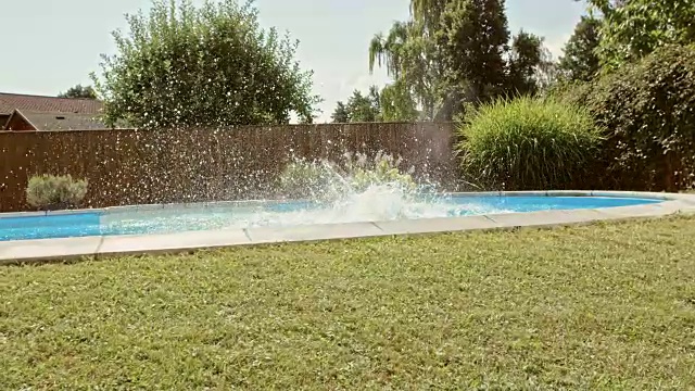母亲和女儿跳入游泳池在一个夏天的一天视频素材