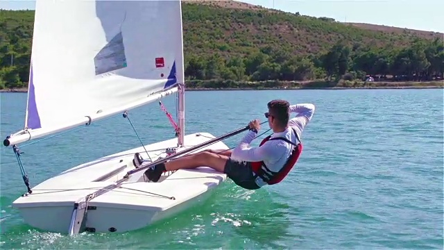 高清手持:拍摄的年轻船夫航行在激光级船视频下载