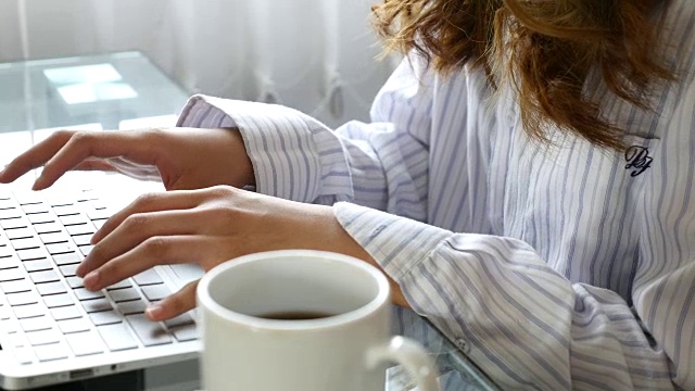女人用笔记本电脑工作，咖啡杯，电脑，4K(超高清)视频素材