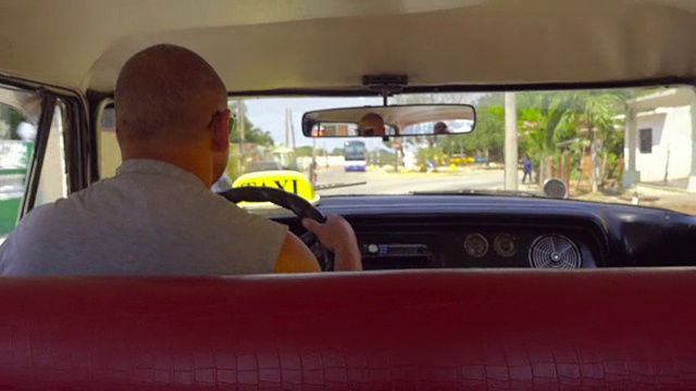 POV内部古巴老爷车。乘坐一辆老式的美国出租车旅行。我们可以从后面的视角看到司机。像当地人一样旅行视频素材