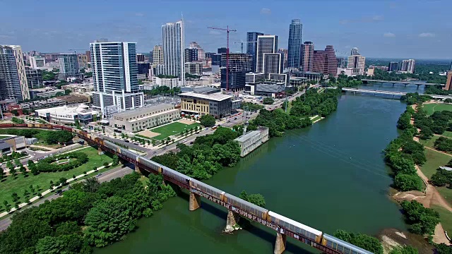高空中拍摄的天际线城市景观与火车横跨科罗拉多河奥斯汀市中心4K视频下载