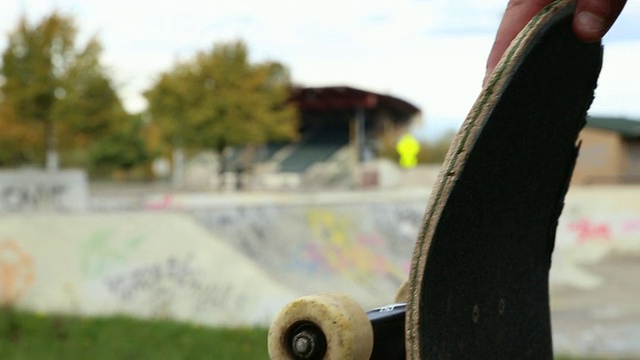 一个滑板手站在滑板公园里。视频下载