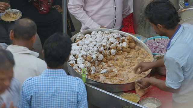印度新德里，一名男子在市场上供应食物视频下载