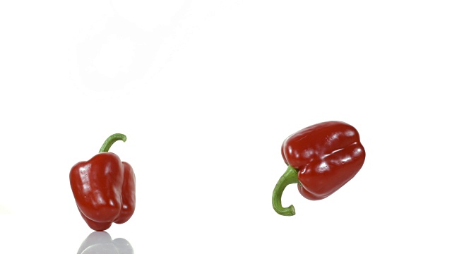 红甜椒，辣椒，蔬菜在白色背景下落下碎裂，慢镜头4K视频素材