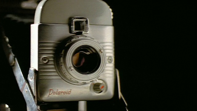 近距离跟踪拍摄过去的旧宝丽来相机与黑色背景视频素材