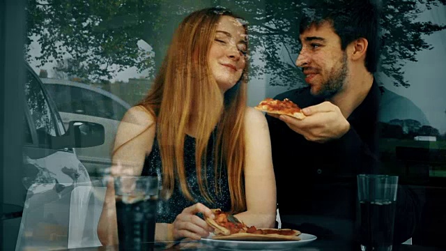 披萨，餐馆里的小情侣，窗外的倒影。视频素材