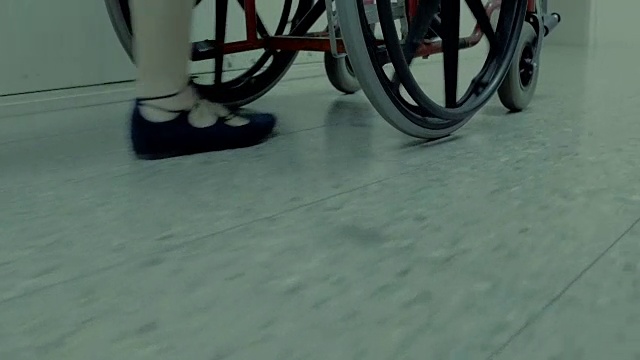 穿着芭蕾平底鞋的女人推着空轮椅视频素材