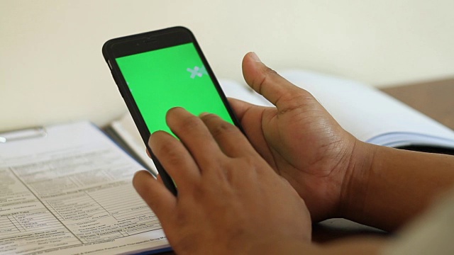 男人的手触摸和滚动智能手机的绿色屏幕视频素材