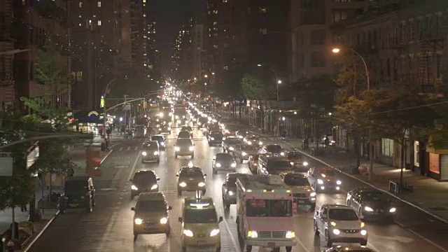 夜间在城市街道上上下班的汽车。交通信号灯的背景视频素材