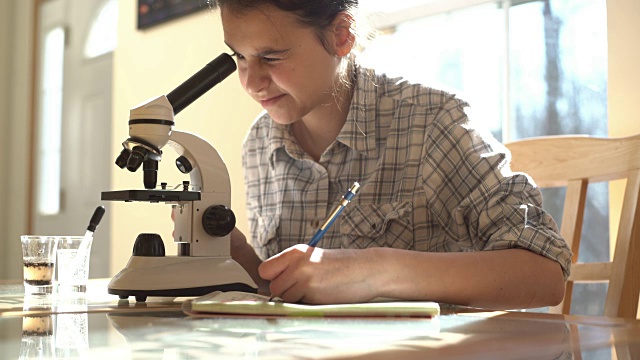 十几岁的女孩用显微镜做实验室工作视频下载